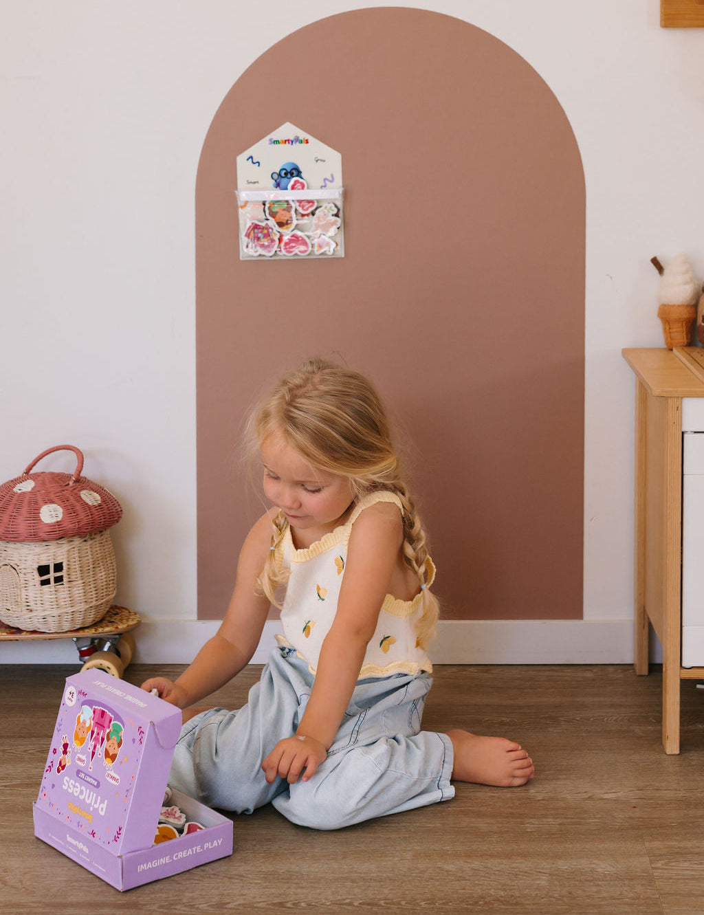 Child playing independently with magnetic toys on a play wall