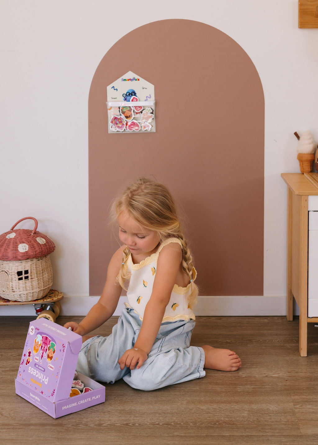 Child building fine motor skills while playing with magnetic shapes on a SmartyPals play wall